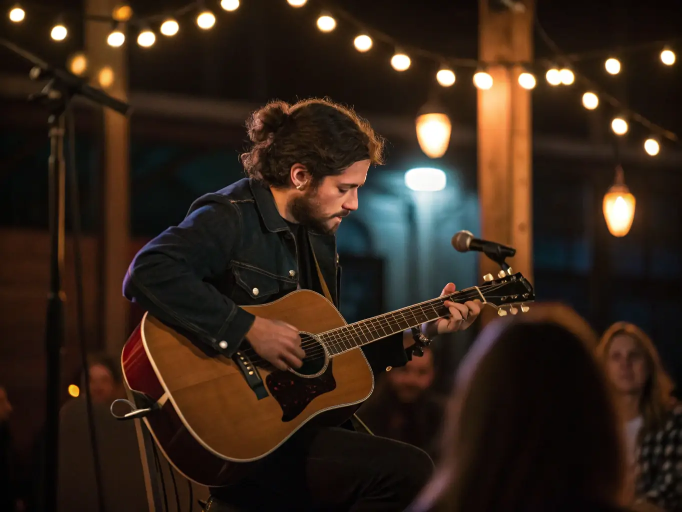 A solo musician playing an acoustic guitar on a small stage at Celtic Inn, with a focused spotlight and a captivated audience listening attentively.